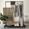 free standing display rack with rail from water pipes and shelf for bags and decoration