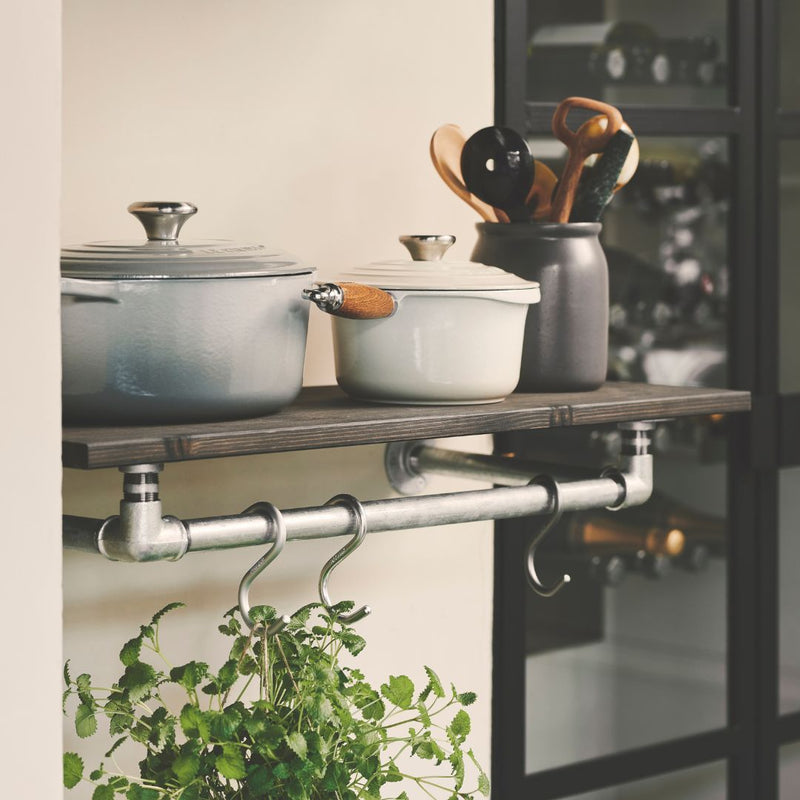 Wall mounted wooden shelf to store pots in the kitchen with rail underneath to hang herbs